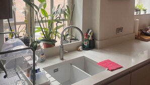 A kitchen with a sink, window, and potted plants. - Fabulous 2-bedroom apartment in NW8 London perfect for your stay (London)