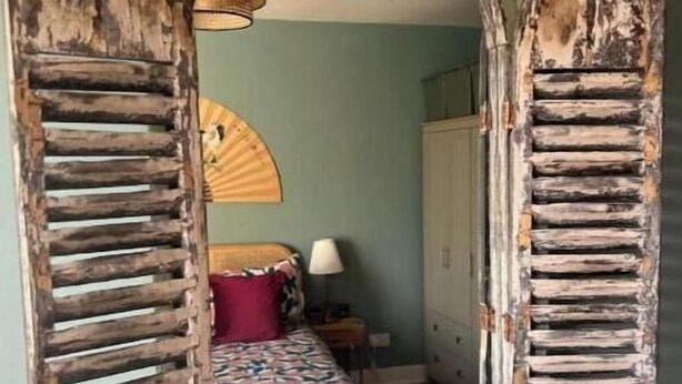 A room with a bed, a lamp, and a wardrobe. - Stylish Family Home with Garden near Tottenham Stadium & Easy Central Access (London)