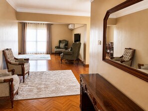 A spacious living room with a large mirror, wooden furniture, and a view to the outside. - Spacious Apartment Cairo (Cairo Governorate)