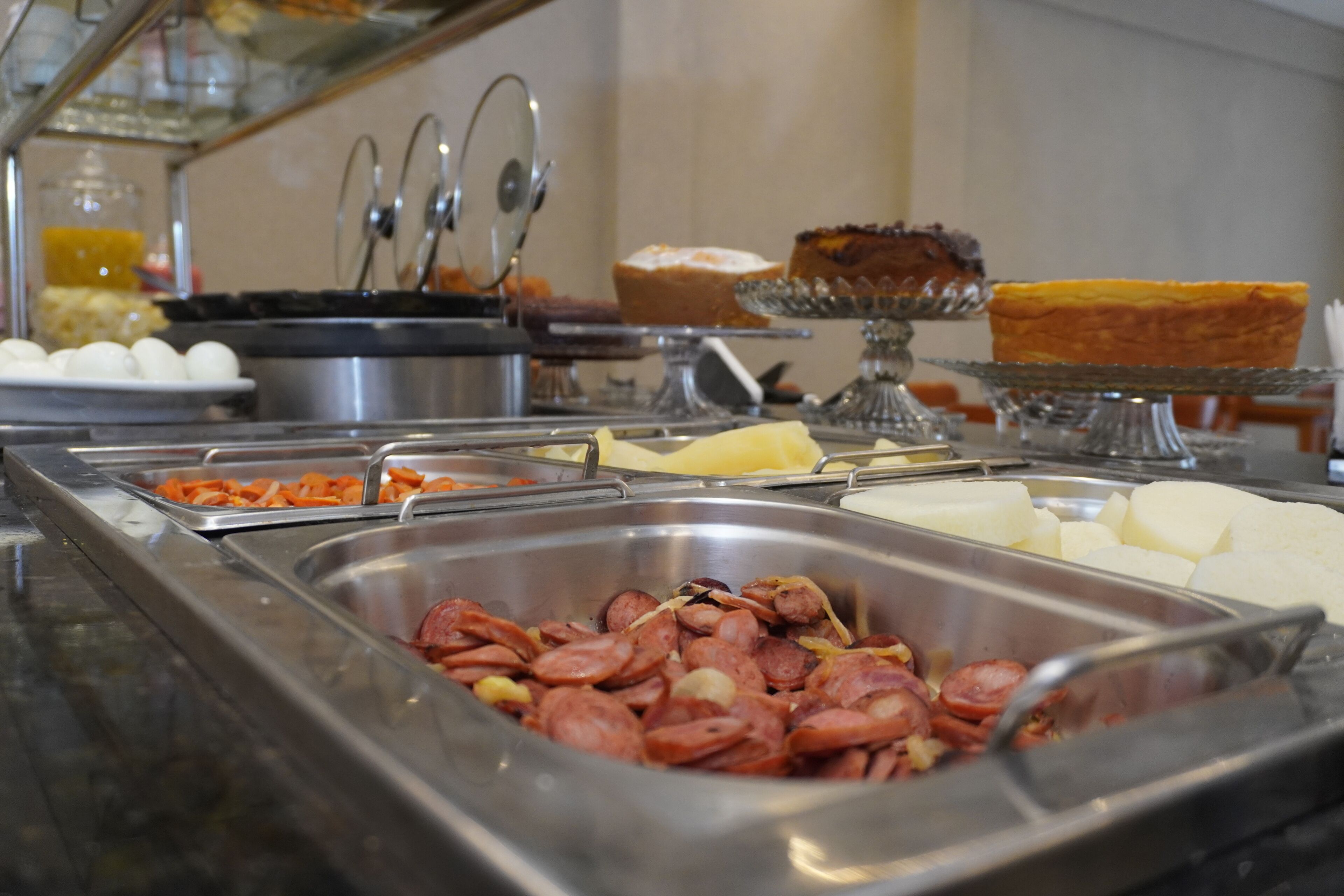 En buffet med et udvalg af madvarer, herunder kød, oste og desserter.