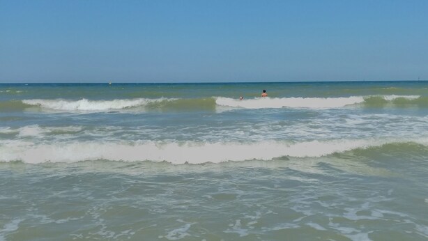 A beach with waves and a clear sky. - Le Chalet des Moineaux (Ouistreham)