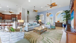 A spacious living room with a sofa, coffee table, and a large tropical-themed rug. - Mar3507 3 Bedroom Home (Punta Gorda)