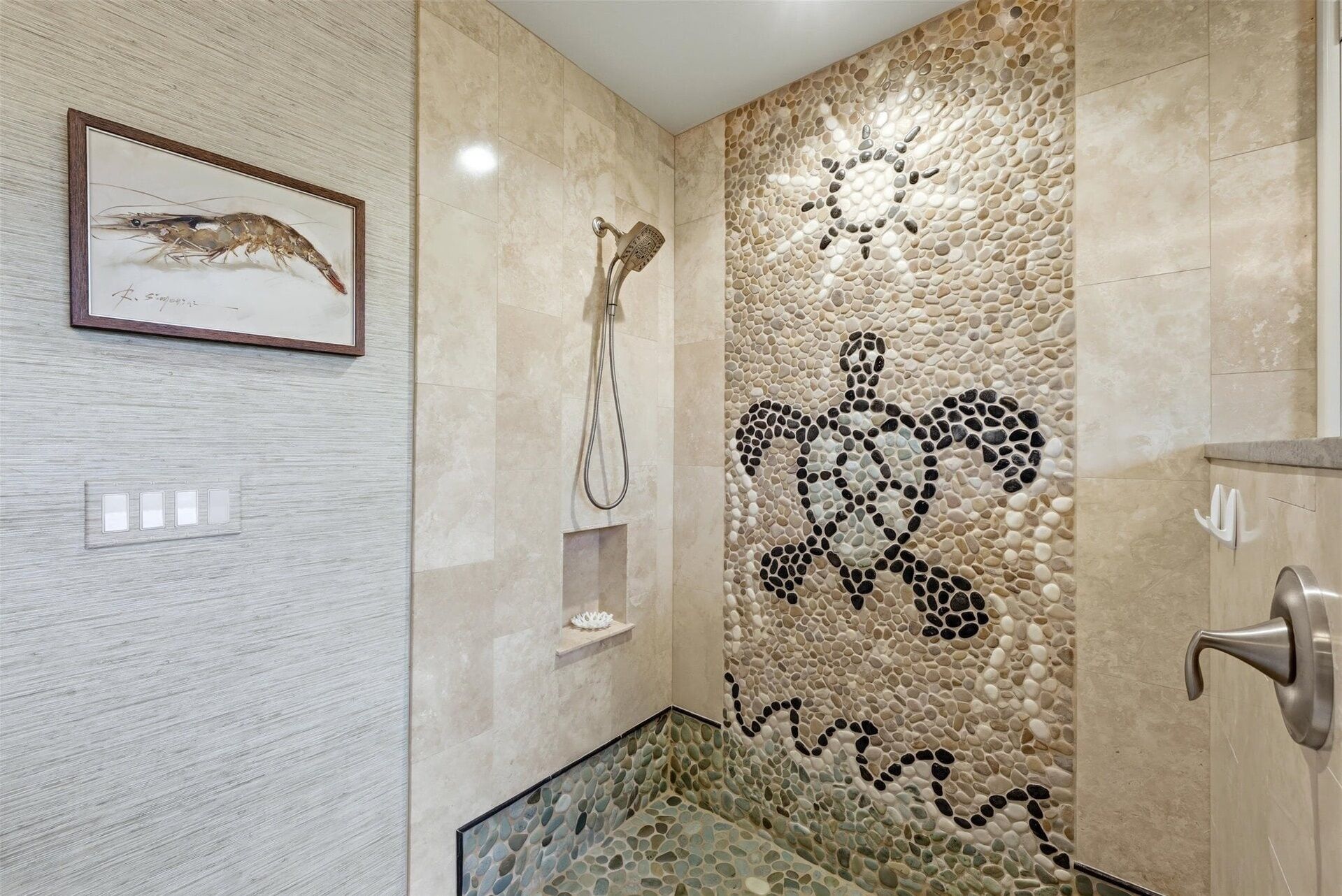 Een badkamer met een mozaïekwand, een ingelijste foto van een garnalen, een douche en een zithoek met glazen wanden.