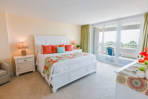 A bedroom with a bed, nightstands, a dresser, a balcony with a view, and a chair. - 329 North Hampton, Expansive Balcony & Resort Amenities 2 Bedroom Condo (Myrtle Beach)