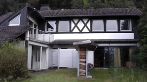 Una casa de dos plantas con balcón, ventanas amplias y garaje.