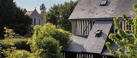 A traditional house with a steeply pitched roof, a visible chimney, and a small window.