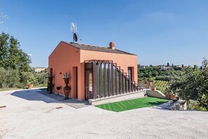 Un edificio moderno con tetto inclinato, ampie finestre e un'area verde con prato.