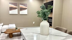 A modern living room with a marble island, a wooden coffee table, a sofa, and two framed artworks on the wall. - Walk to DPAC + Bulls - Chic Downtown Durham condo (Durham)