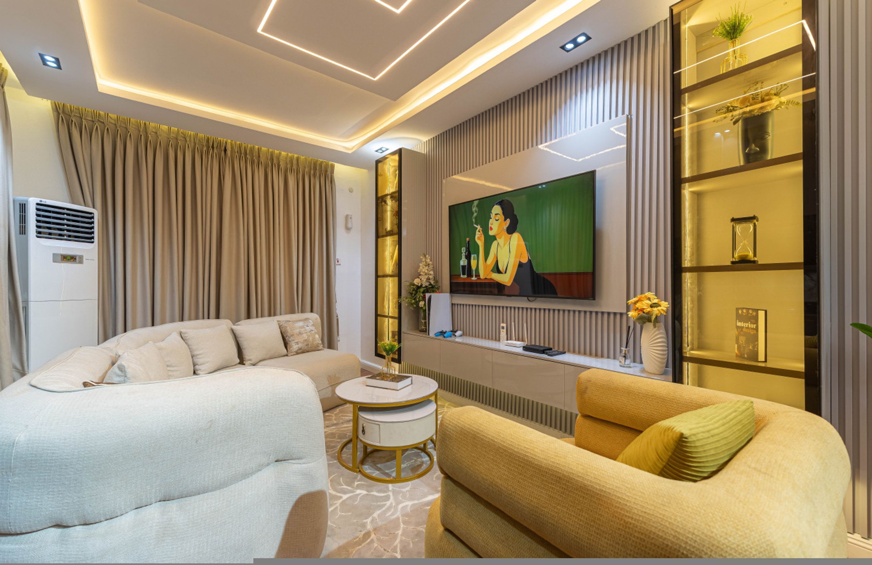 Una sala de estar moderna con un sofá, una mesa de centro, un televisor y una estantería decorativa.
