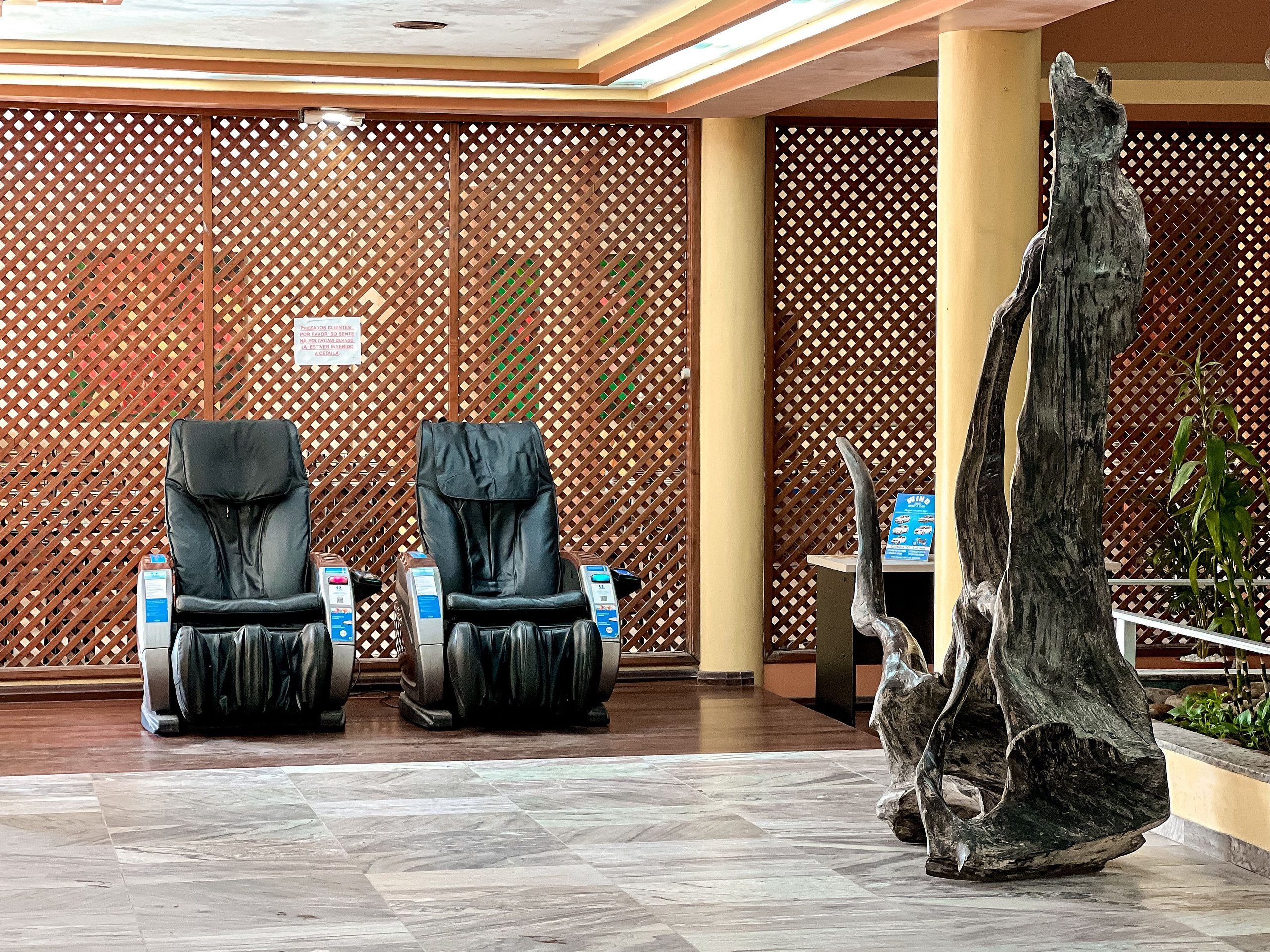 A spa area with massage chairs and a wooden sculpture.