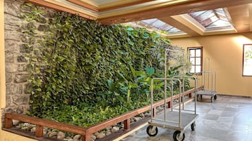 Une pièce avec un mur en pierre, un banc en bois et un chariot en métal.