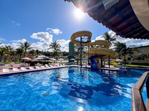 A swimming pool with water slides, lounge chairs, and umbrellas. - Porto Belo Park (Porto Seguro)