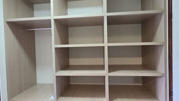 A wooden wardrobe with multiple compartments and drawers.
