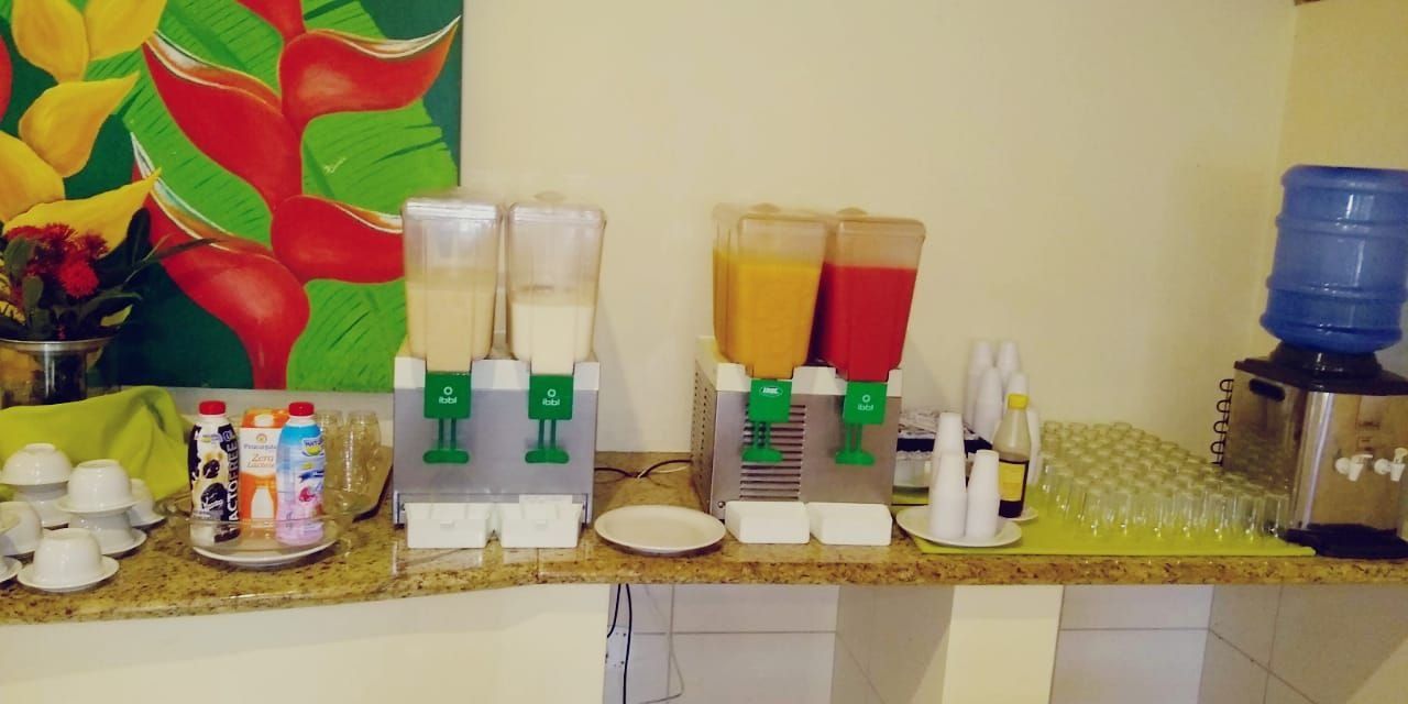 A kitchen counter with a juicer, a water dispenser, and various kitchen items.