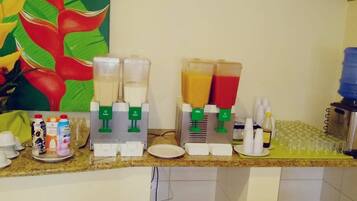 A kitchen counter with a juicer, a water dispenser, and various kitchen items.