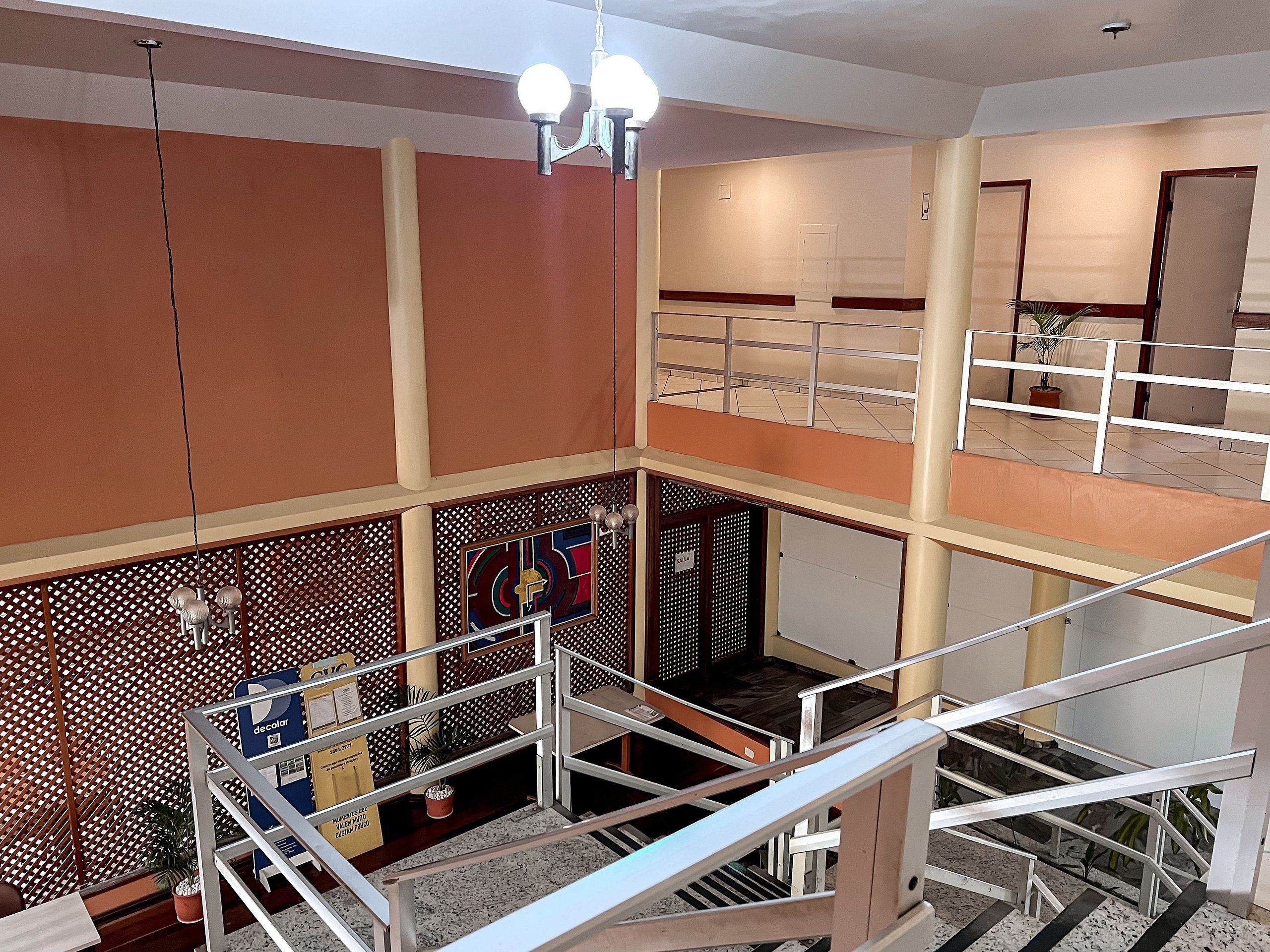 A multi-level interior with a staircase, a decorative wall with a geometric pattern, and a ceiling light fixture.