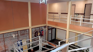 A multi-level interior with a staircase, a decorative wall with a geometric pattern, and a ceiling light fixture.