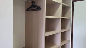 A walk-in closet with multiple shelves and a hanging rod.
