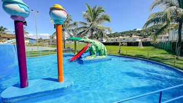 A swimming pool with a slide and a frog-themed water feature.