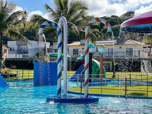 A swimming pool with water features, including two candy cane-like structures and a water slide. - Porto Belo Park (Porto Seguro)