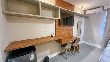 A compact kitchenette with a built-in trash bin, a small refrigerator, and a microwave.
