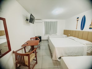 A hotel room with a bed, a desk, a chair, a television, and a window with curtains. - Porto Belo Park (Porto Seguro)