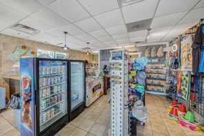Ein Ladeninneres mit einem Pepsi-Kühlschrank, einer Präsentation für Foster Grants und verschiedenen Artikeln auf Regalen.