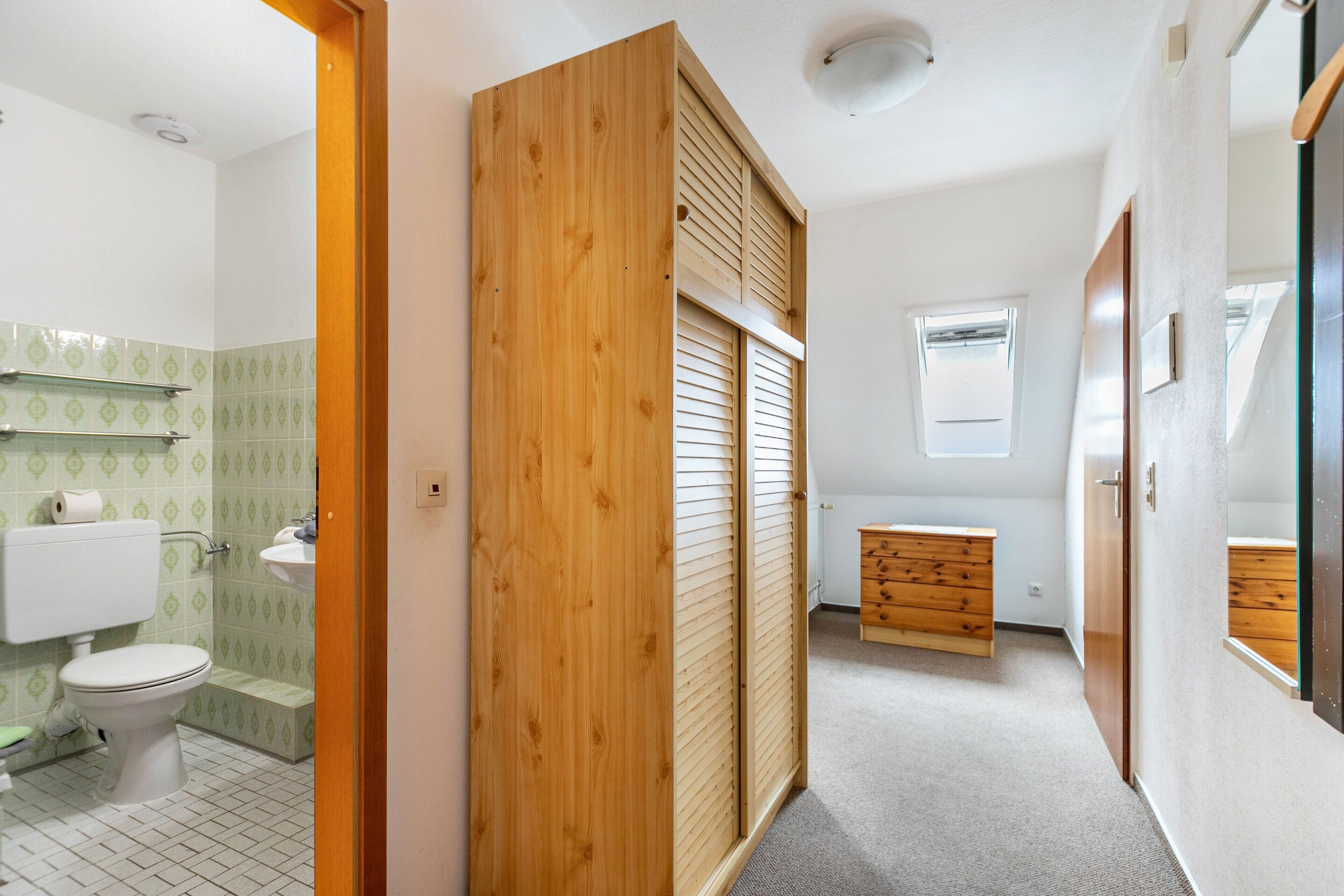 Une salle de bain avec des toilettes, un lavabo et un meuble en bois.