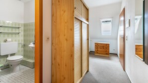 Ein Badezimmer mit Toilette, Waschbecken und Holzschrank.