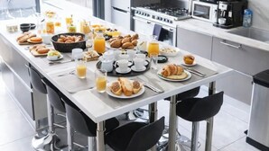 Una cocina moderna con comedor, electrodomésticos de acero inoxidable y espacio para el desayuno.