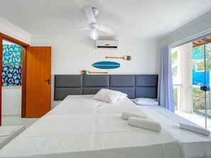 Une chambre d’hôtel équipée d’un lit, d’un ventilateur de plafond, d’un appareil de climatisation et offrant une vue sur l’extérieur.
