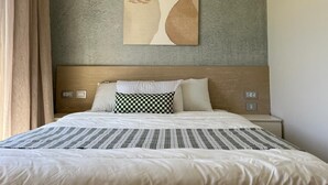 A hotel room with a bed, a headboard, a wall-mounted artwork, and a nightstand. - Fouka North Coast SA-8A-G03 (Marsa Matrouh)