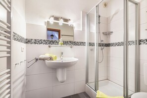 A bathroom with a sink, mirror, towel rack, and glass-enclosed shower. - Apartment 'Nr 06' with Wi-Fi (Büsum)