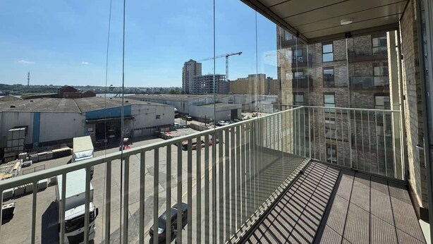 Un balcon donnant sur un chantier de construction et des immeubles.