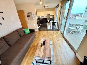 Eine moderne Wohnung mit Wohnzimmer, Küche und Balkon.
