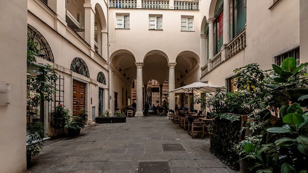 A courtyard with stone flooring, arches, and outdoor seating. - [Historic Palace Duplex] Cruise 2 min • A/C • WiFi (Savona)