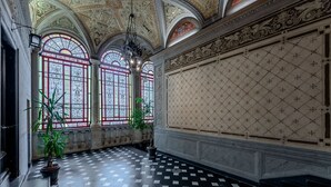 A grand hall with ornate ceiling, large windows with stained glass, and a checkered floor. - [Historic Palace Duplex] Cruise 2 min • A/C • WiFi (Savona)