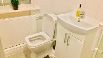 Ein kleines Badezimmer mit Toilette, Waschbecken und einem Schrank.
