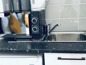 A kitchen with a coffee machine, a sink, and a countertop. - Studio flat en-suite, Kitchenette, Parking, NP7 (Newbury Park)