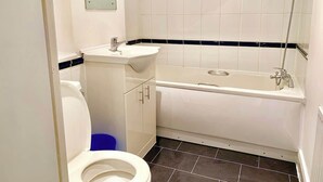 Un bagno con il water, lavandino e vasca da bagno.