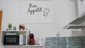 Een keuken met een magnetron, broodrooster en een bord waarop 'Bon Appetit' staat.