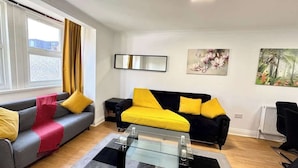Een woonkamer met een bank, een salontafel en een radiator.