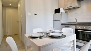 A modern kitchen with white cabinetry, a built-in oven, and a dining area with a table set for four. - Cozy and bright 60 square meters apartment, perfect for four people, located on the first floor of a renovated building without an elevator.The property is located in a quiet area in the Crocetta neighborhood and is well connected to the rest of the city (Turin)