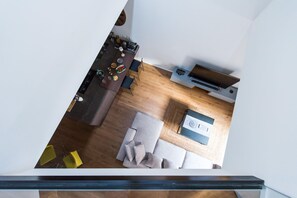 A modern kitchen with a dining area, a wooden floor, and a built-in TV. - The Tomato Factory House: A Green Oasis in Palermo (PALERMO)