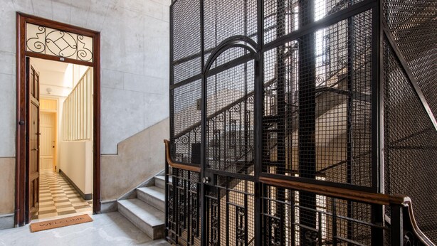 Una scala con ringhiera in metallo e stipite in legno.