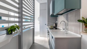 Una cucina moderna con lavello, fornello e pensili.