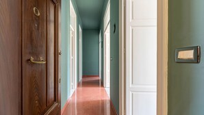 Ein Flur mit Holztüren, einem roten Teppich und teal-farbenen Wänden.
