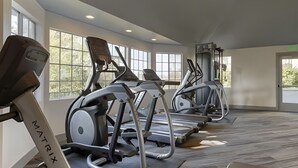Una palestra con tapis roulant, cyclette e vogatore.