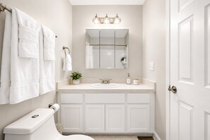 Un baño con inodoro, lavabo y perchero para toallas.