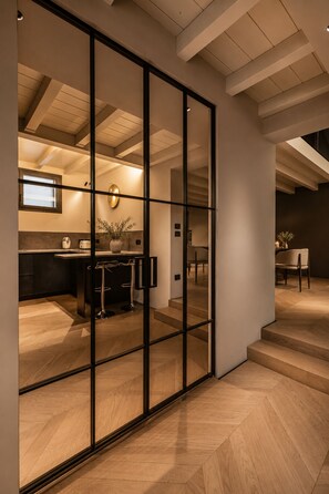 A modern interior with a kitchen, dining area, and a staircase. - ASTRA PENTHOUSE (Bologna)
